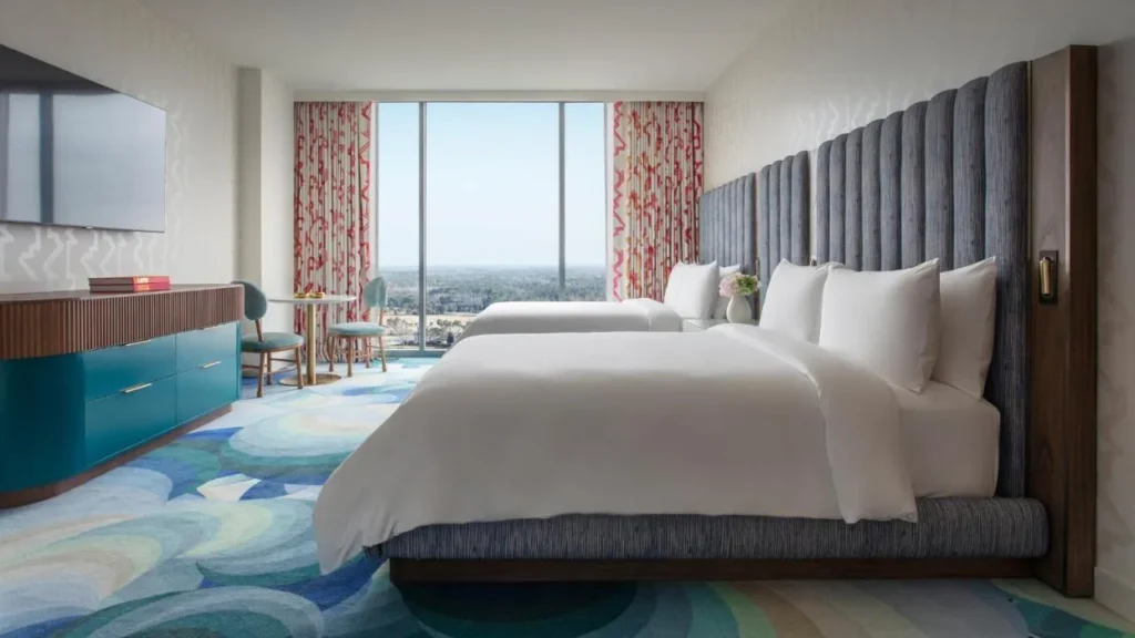 Dos camas queen, cabeceros azules altos y una ventana ancha en Lake Nona Wave Hotel