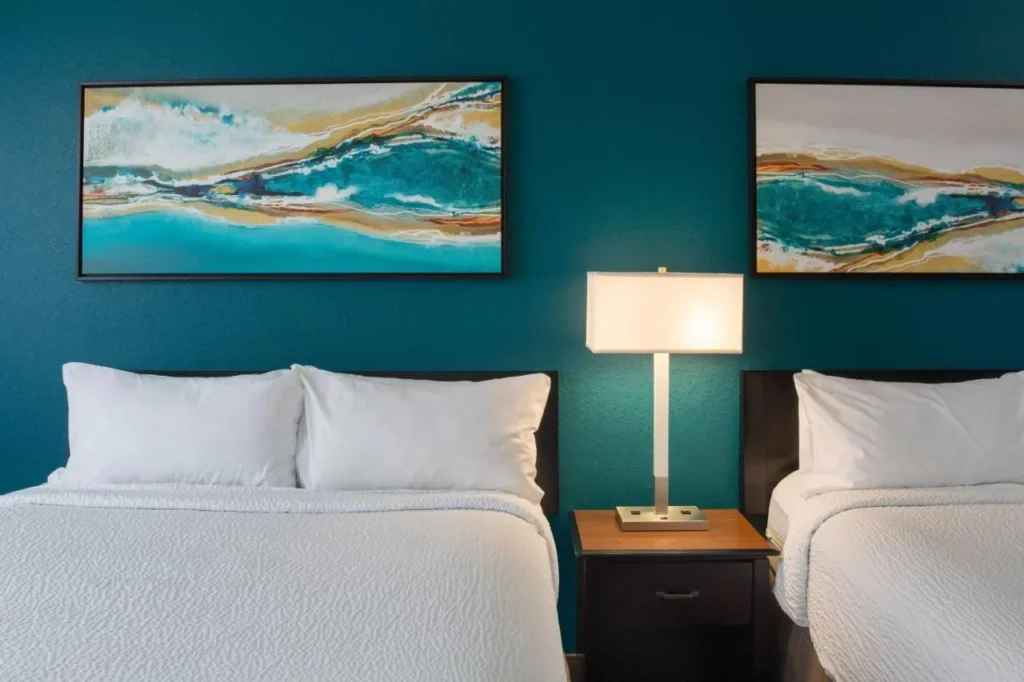 Dos camas queen bajo el arte abstracto en una pared de color verde azulado, Residence Inn Orlando at SeaWorld