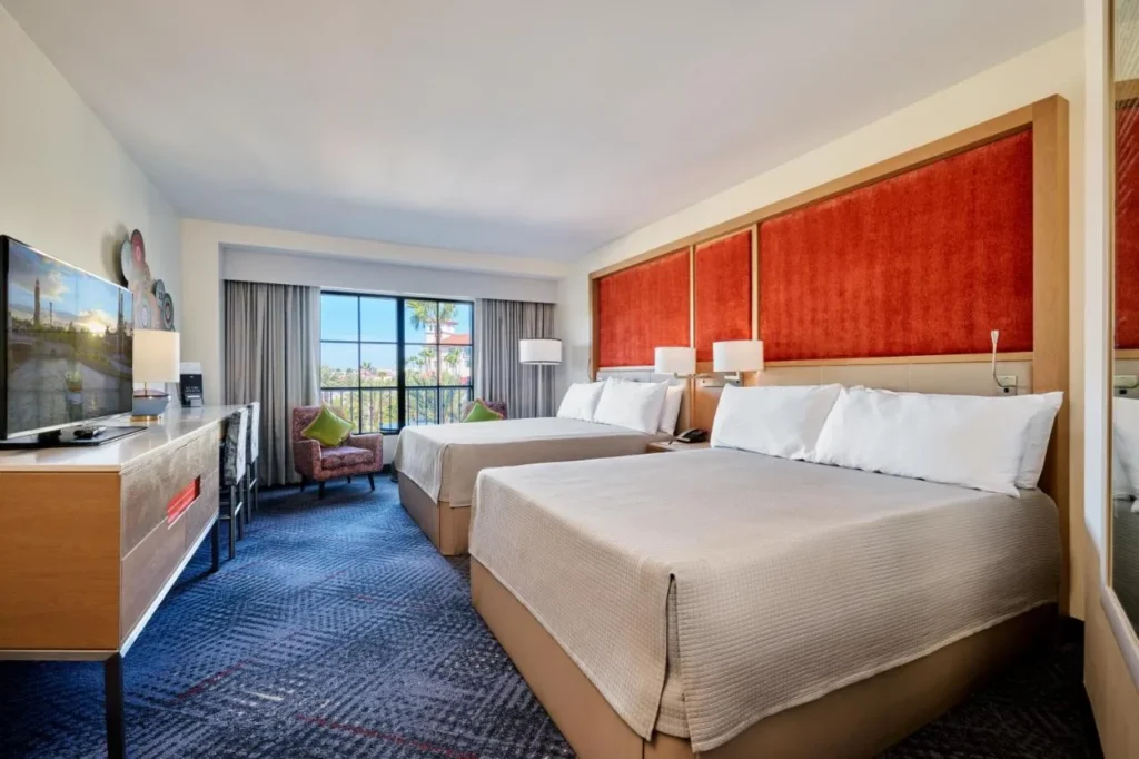 Two queen beds with red headboard wall and a balcony window at Hard Rock Hotel Orlando