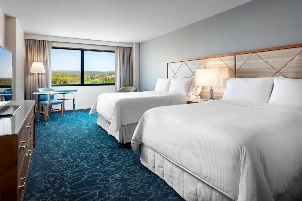 Habitación de dos camas queen en el Walt Disney World Dolphin con alfombra azul y una amplia ventana