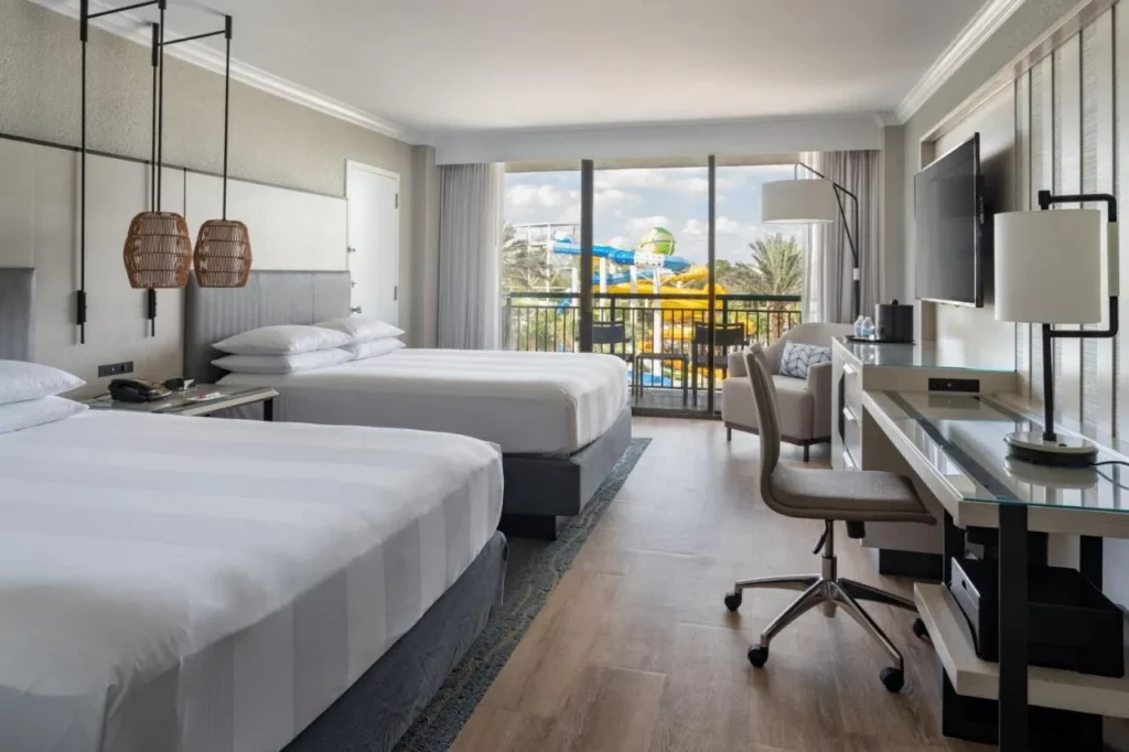 habitaci&oacute;n con dos camas queen con un balc&oacute;n frente a los toboganes del parque acu&aacute;tico en Orlando World Center Marriott