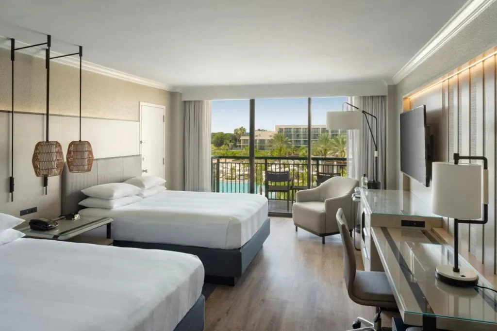 habitaci&oacute;n con dos camas queen con balc&oacute;n con vistas a la zona de la piscina en el Orlando World Center Marriott