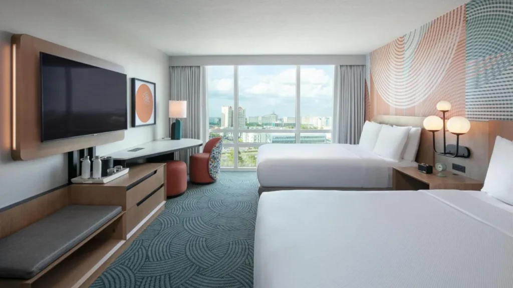 habitaci&oacute;n con dos camas queen con una pared caracter&iacute;stica con motivos y una gran ventana en el Hotel Landy Orlando