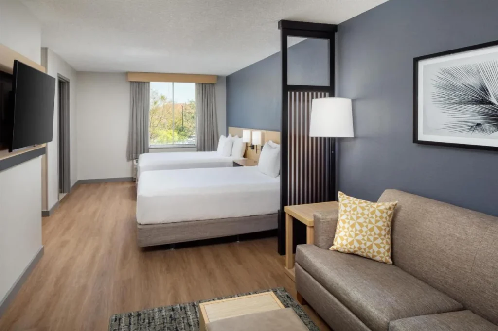 habitación con dos camas queen con sofá-cama y suelo de madera en Hyatt Place Lake Mary/Orlando-North