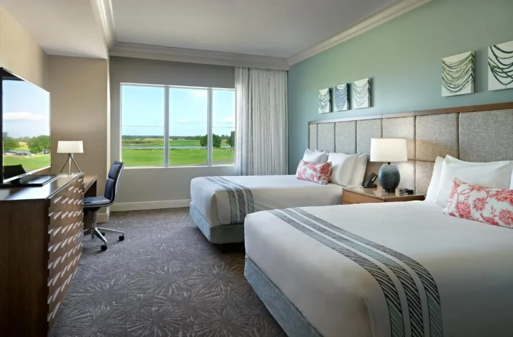 Two-queen room with a window facing the golf course at Omni Orlando Resort at ChampionsGate
