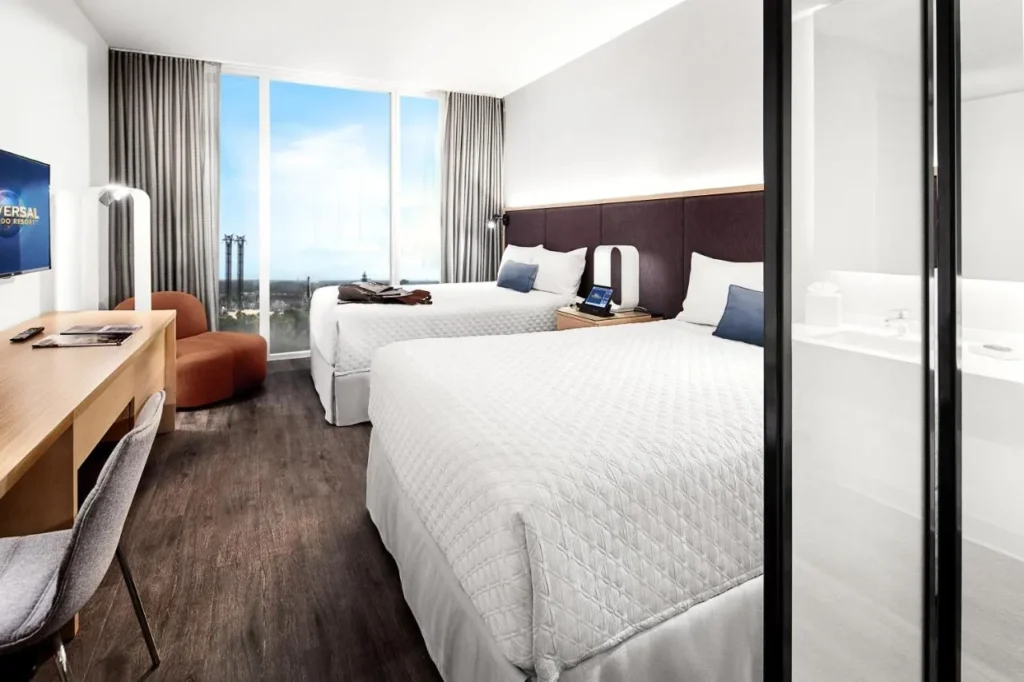 habitaci&oacute;n con dos camas queen con ventanas de piso a techo y una pared de ba&ntilde;o de vidrio, Universal Aventura Hotel