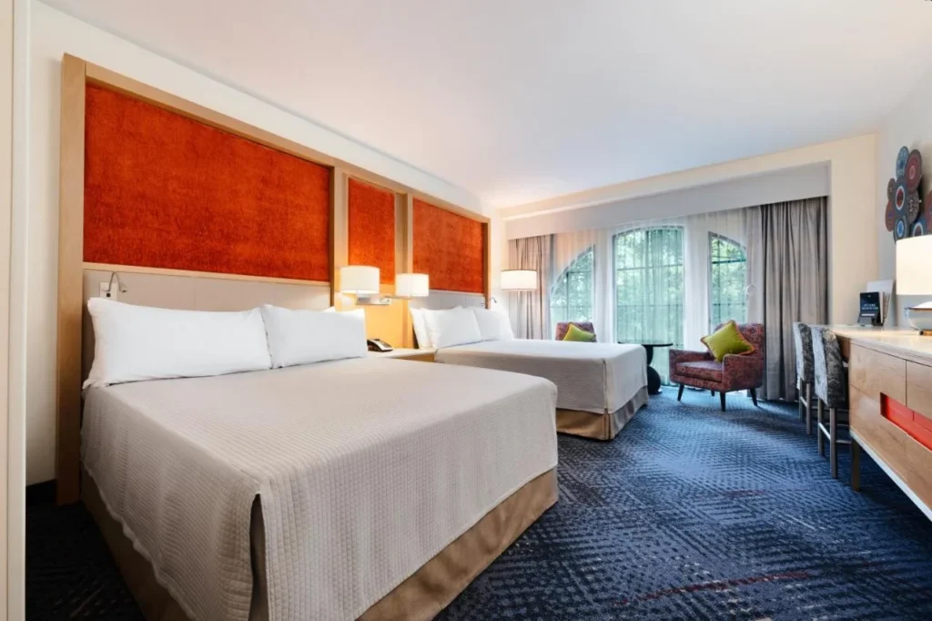 habitación con dos camas queen con paneles de cabecera naranja y ventanas arqueadas en Hard Rock Hotel Orlando