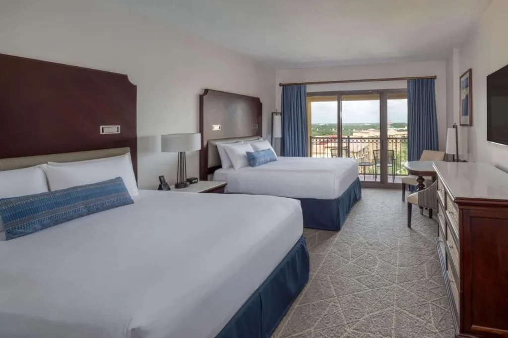 habitación con dos camas queen con puertas correderas a un balcón amueblado en Wyndham Grand Orlando Bonnet Creek