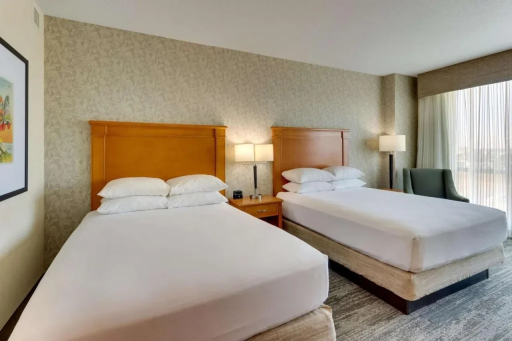 habitación con dos camas queen con cabeceras de madera en Drury Inn & Suites cerca de Universal Orlando