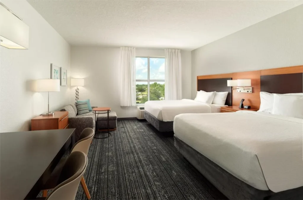 suite con dos camas queen con sof&aacute; y mesa de comedor en TownePlace Suites Orlando at Flamingo Crossings