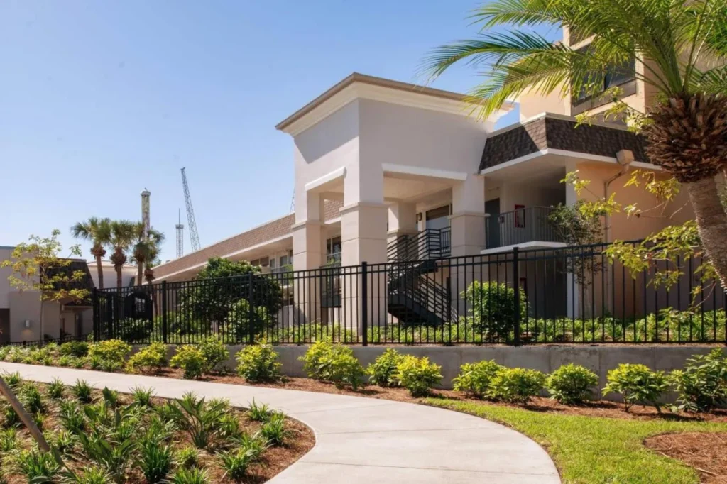 Two-story garden building with outdoor stairs behind a fence and landscaped walkway, Wyndham I-Drive Avanti