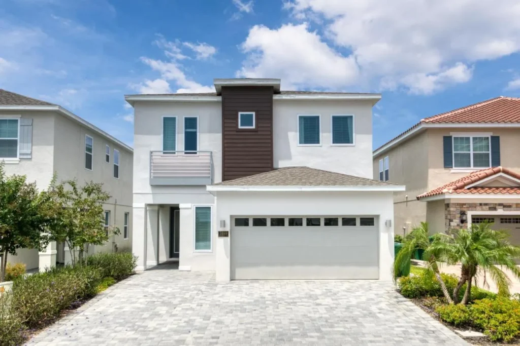 Two-story vacation home at Encore Resort at Reunion with a paved driveway and two-car garage