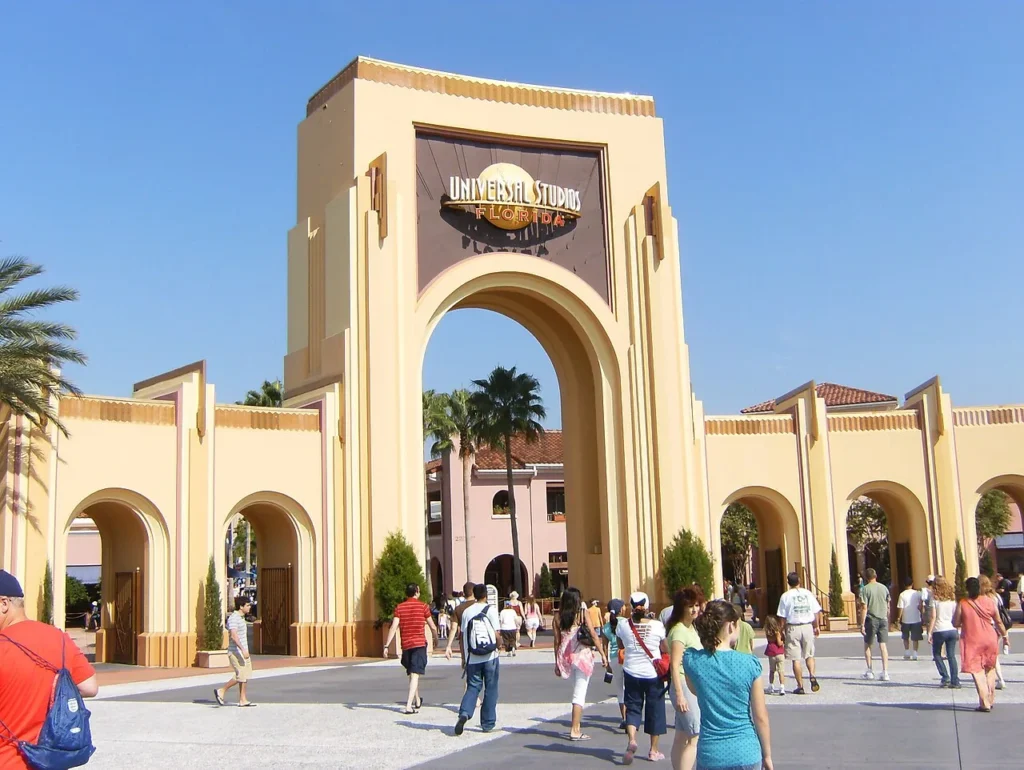Universal Studios Florida entrance arch and gates on a sunny day, with guests walking in