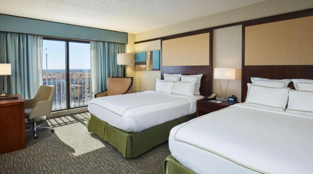 Upper-floor room with two queen beds and a balcony at the DoubleTree Orlando Theme Park Resort