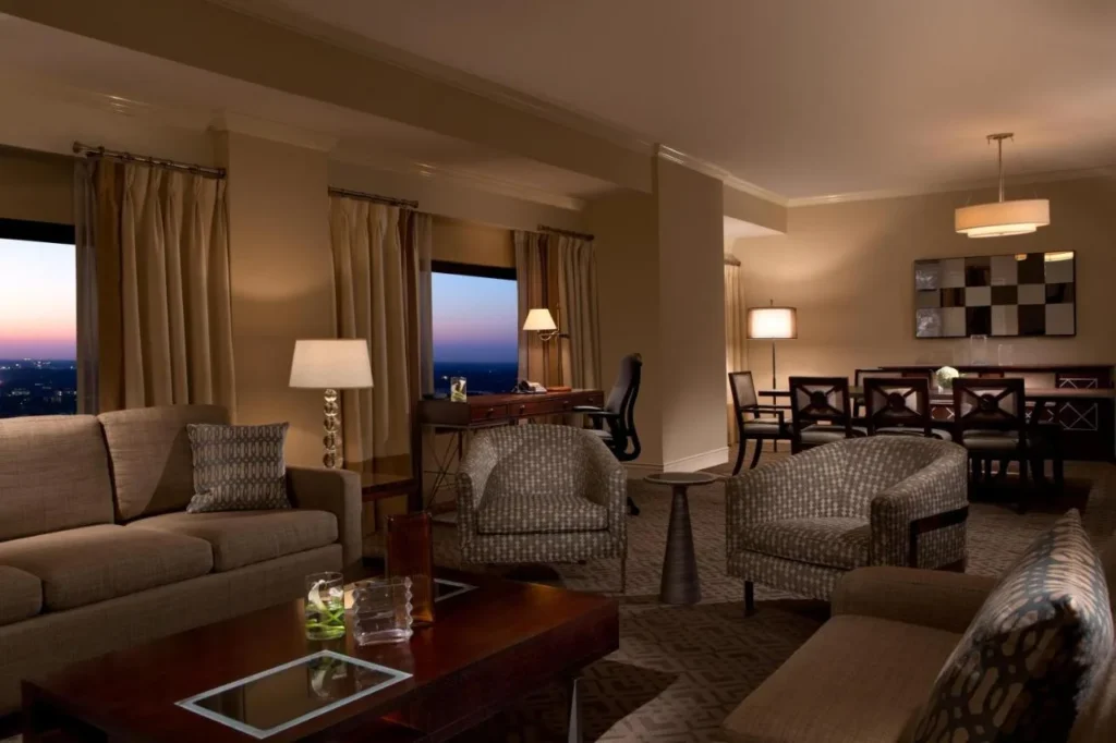 Sala de estar en la suite del piso superior al atardecer con sofás y comedor, Hilton Orlando Lake Buena Vista