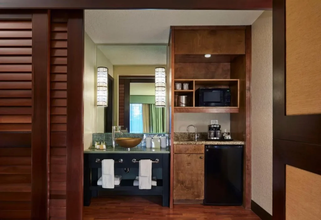 Vessel-sink vanity and wet bar with microwave and fridge at the DoubleTree Orlando Theme Park Resort
