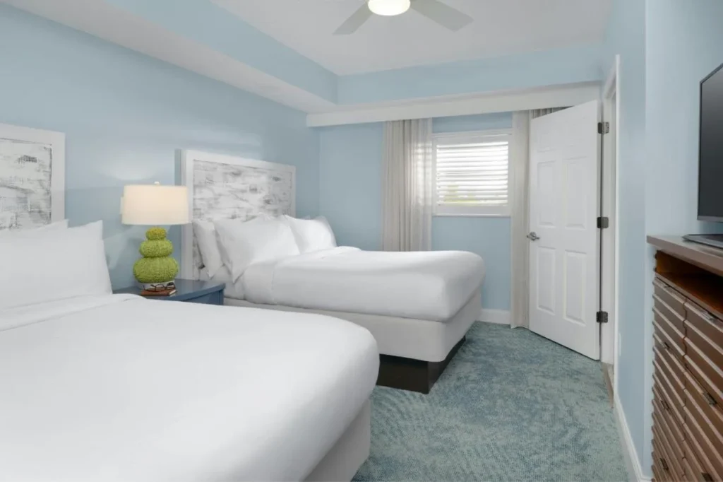 Dormitorio de la villa con dos camas, una cómoda y un televisor en el Marriott's Harbour Lake