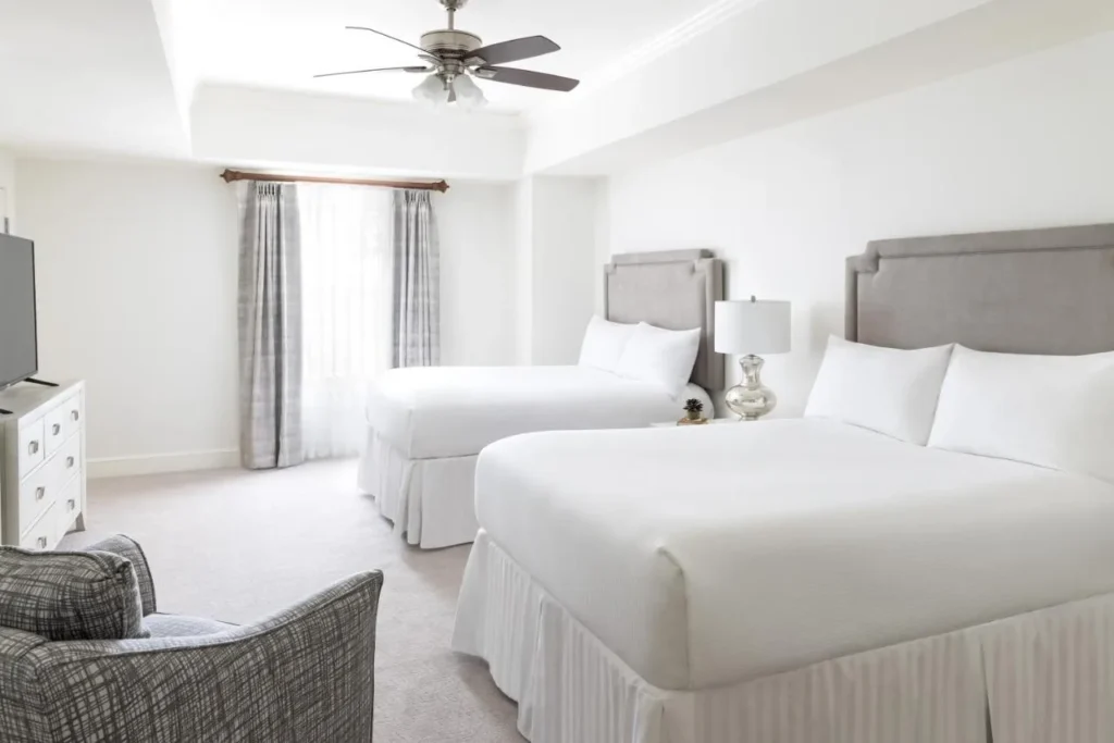 Dormitorio de la villa con dos camas y un sill&oacute;n en el Reunion Resort and Golf Club