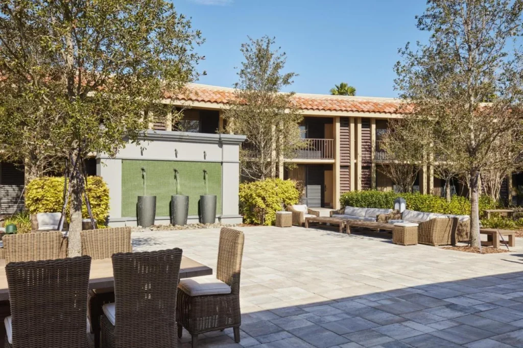 Courtyard de la villa con asientos de mimbre y pared de fuente en DoubleTree Orlando Theme Park Resort