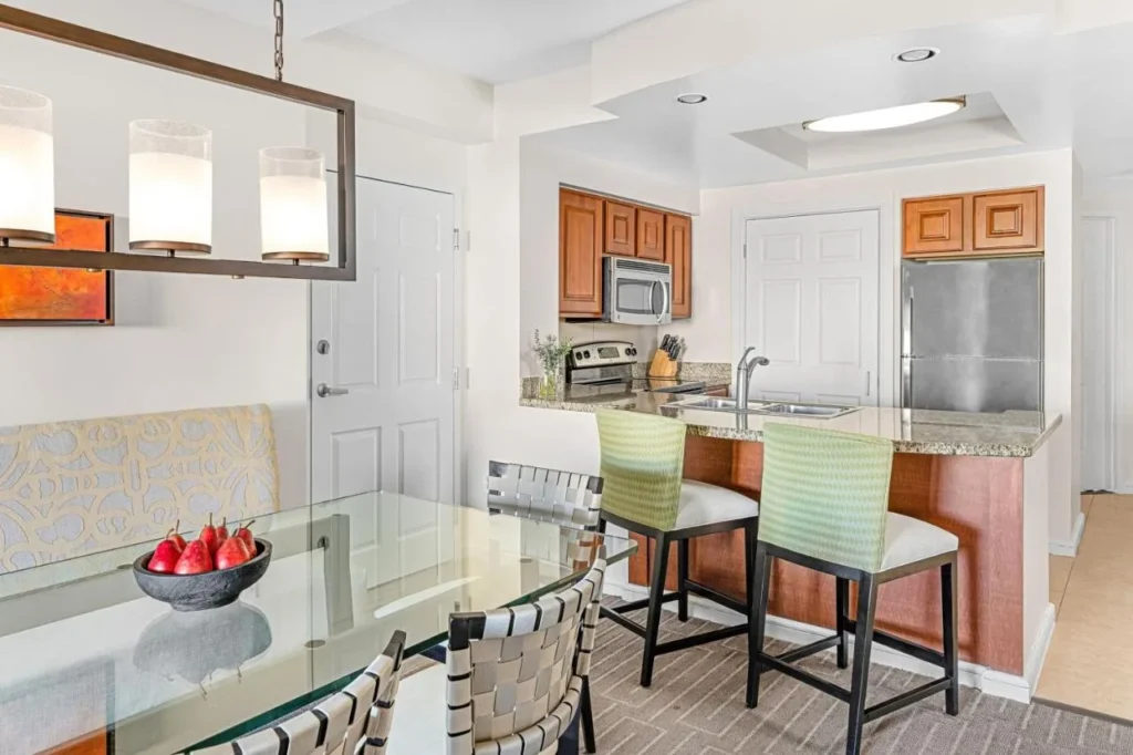 Villa dining table and kitchen with granite bar and stainless refrigerator at Marriott's Grande Vista