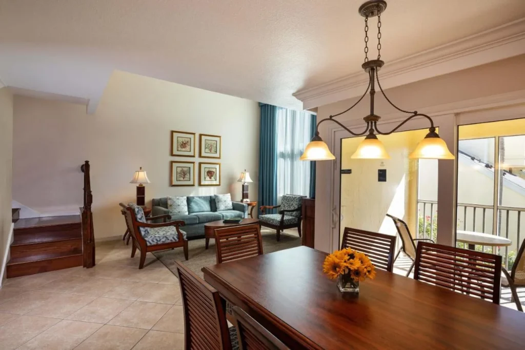 Villa dining table, living area and staircase beside a balcony at Sheraton Vistana Resort