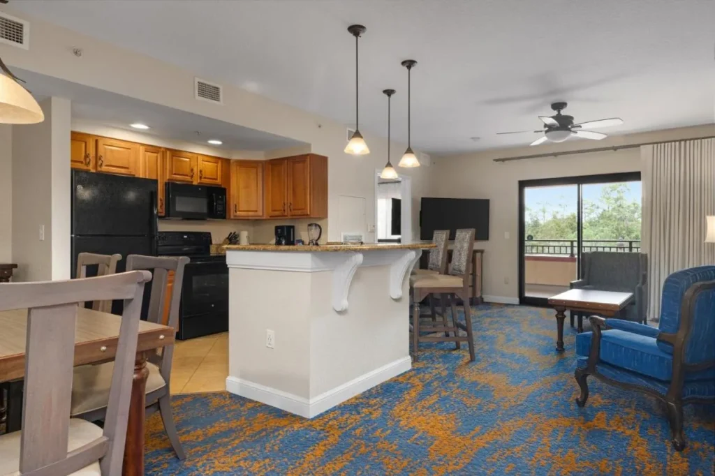 Villa con cocina, mesa de comedor y sala de estar con puerta de balcón en Club Wyndham Bonnet Creek