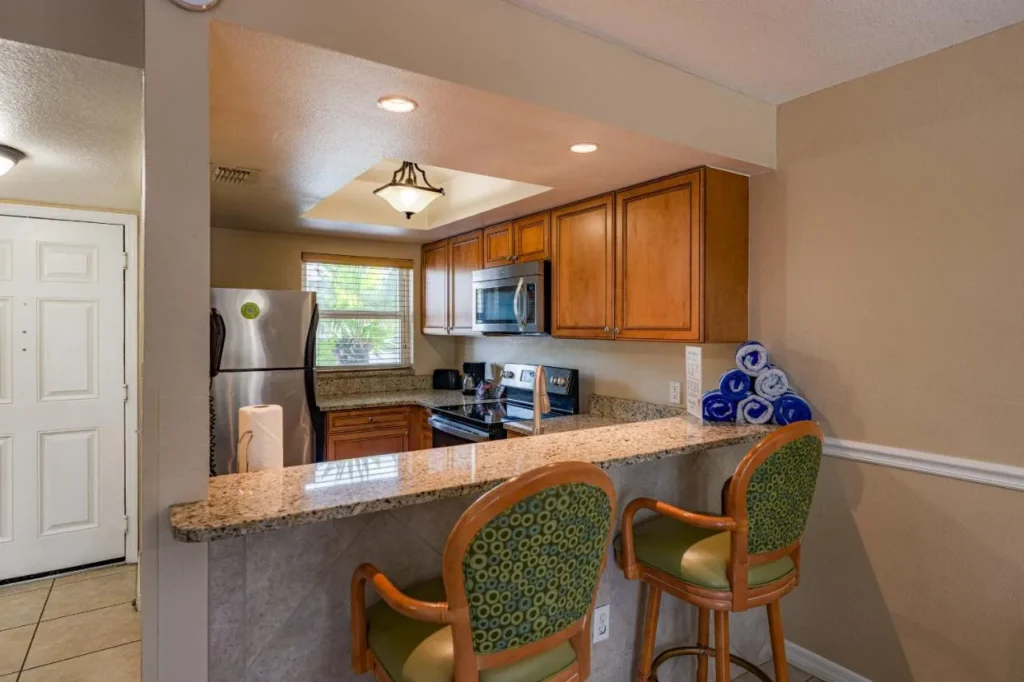 Villa cocina con barra de desayuno y electrodom&eacute;sticos de acero inoxidable en FantasyWorld Resort en Kissimmee
