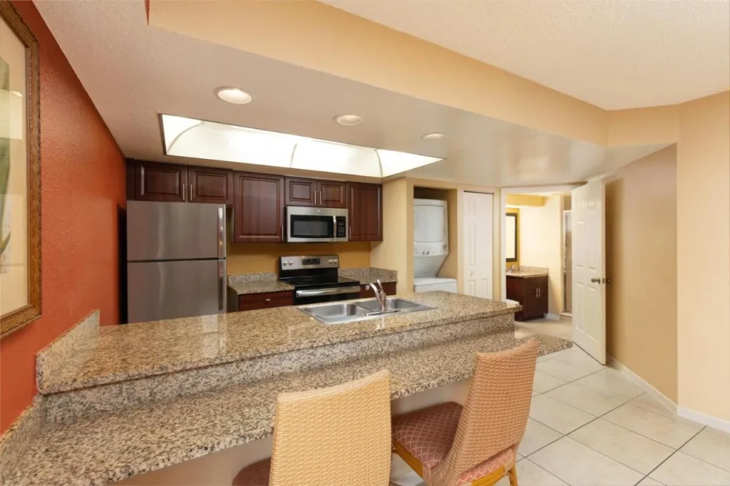 Villa kitchen with granite breakfast bar and stacked washer-dryer at Westgate Vacation Villas Resort