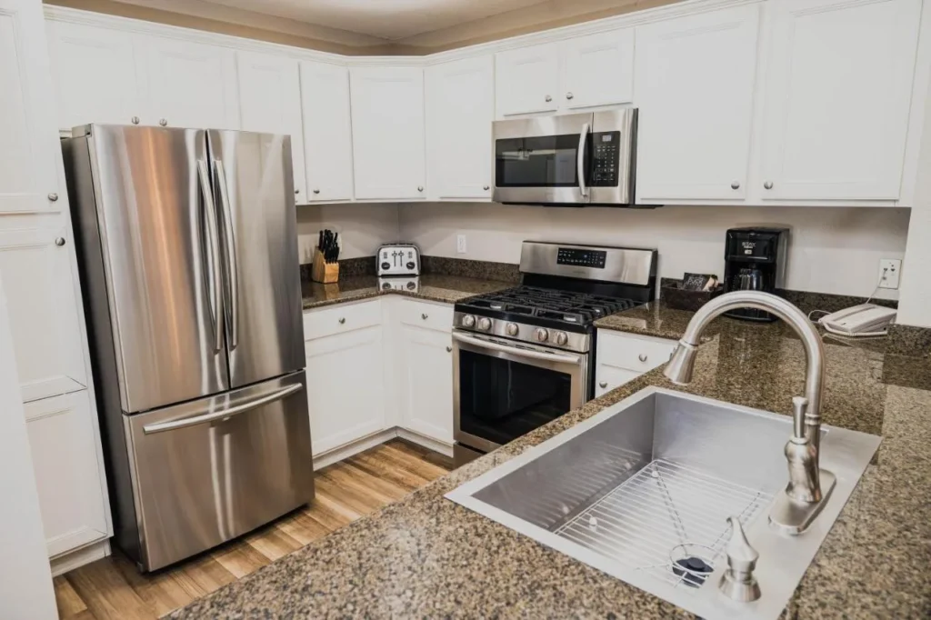 Villa kitchen with granite counters, gas range and stainless steel fridge at Reunion Resort
