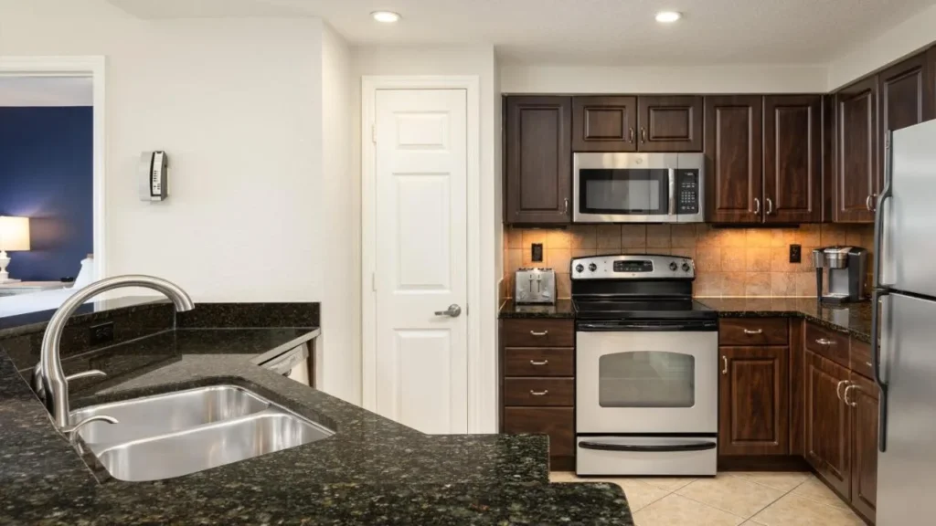 Villa kitchen with granite counters, stainless steel stove, microwave and fridge at Orange Lake Resort