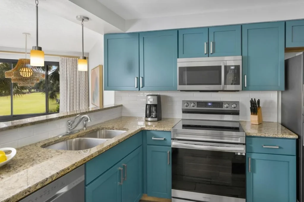 Villa kitchen with teal cabinets, granite counters and a golf-course window at Marriott's Sabal Palms