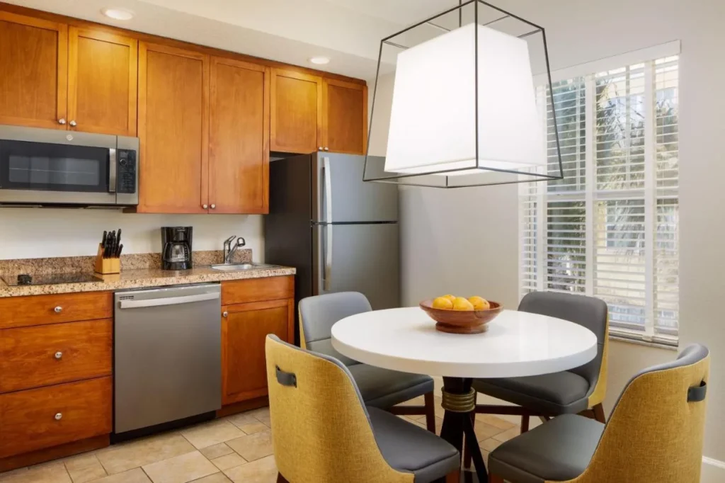 Villa cocineta con placa de cocina, lavavajillas y mesa de comedor redonda para cuatro personas en Sheraton Vistana Villages