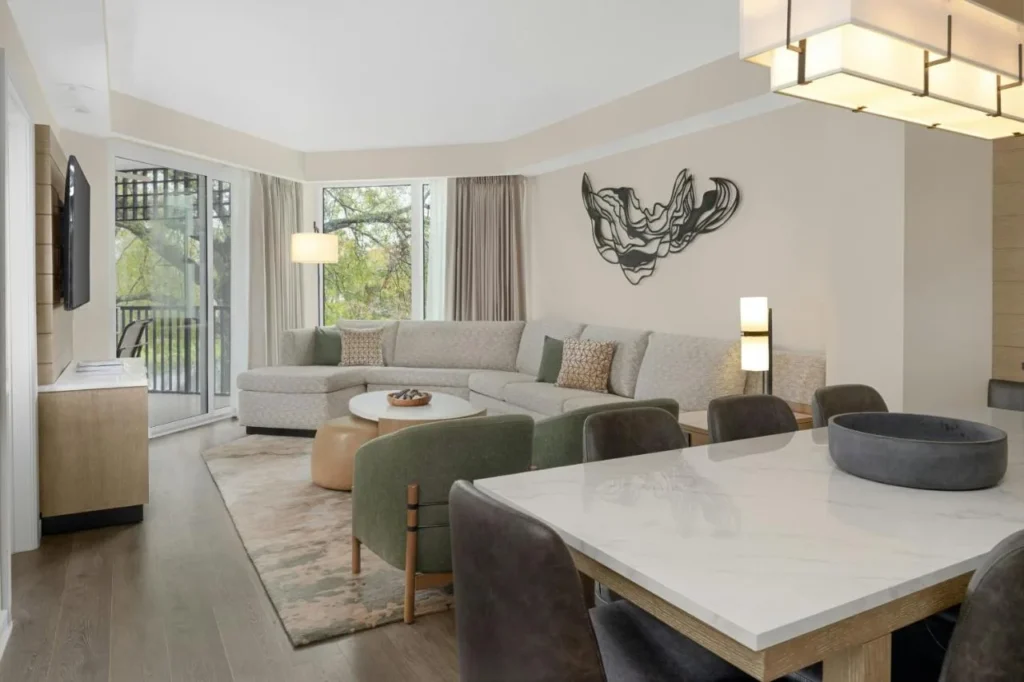 Villa living and dining area with a sectional sofa and stone table at Marriott's Imperial Palms