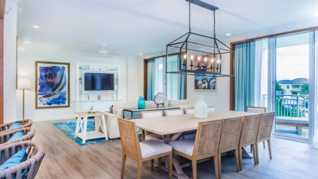 Villa sala de estar con larga mesa de comedor y puerta de balcón en Margaritaville Resort Orlando
