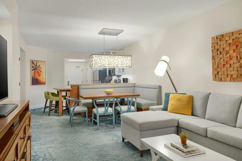 Sala de estar de la villa con una sección gris, cabina de comedor y cocina en Marriott's Harbour Lake