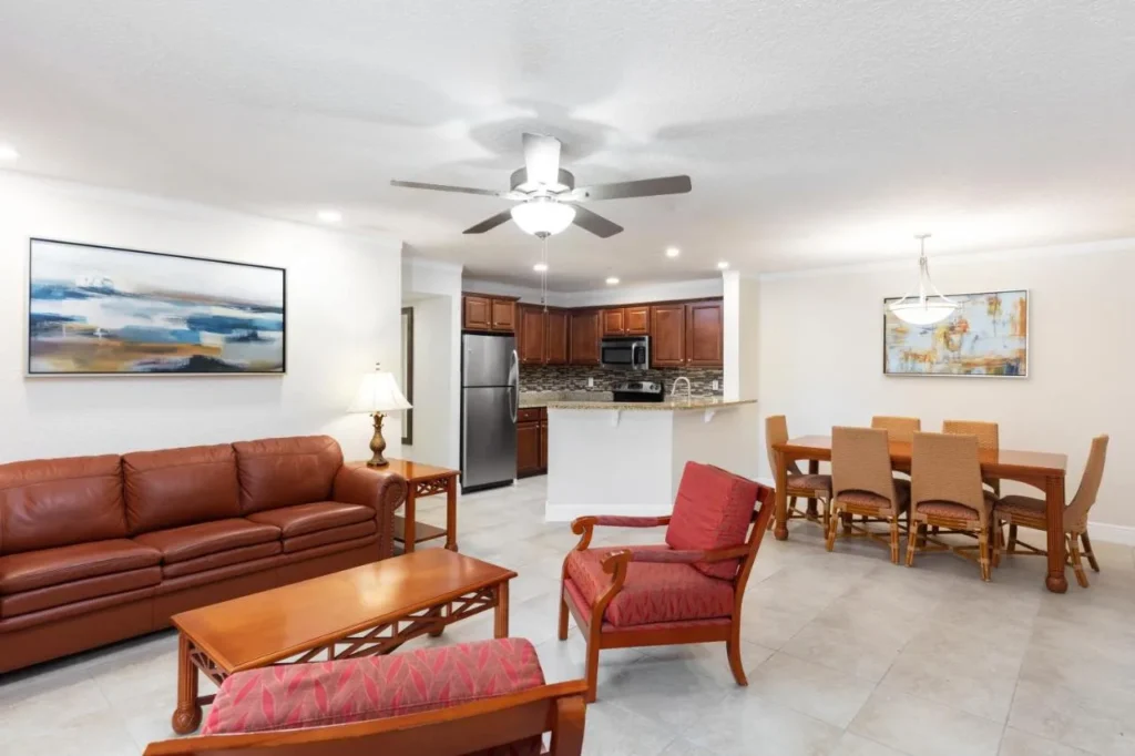 Villa living room with leather sofa, armchairs, dining table and kitchen at Westgate Blue Tree Resort