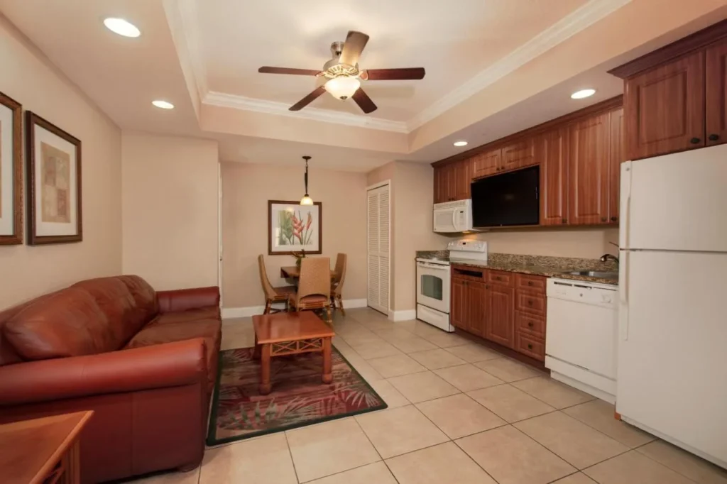 Villa living room with leather sofa, dining table and white-appliance kitchen at Westgate Town Center