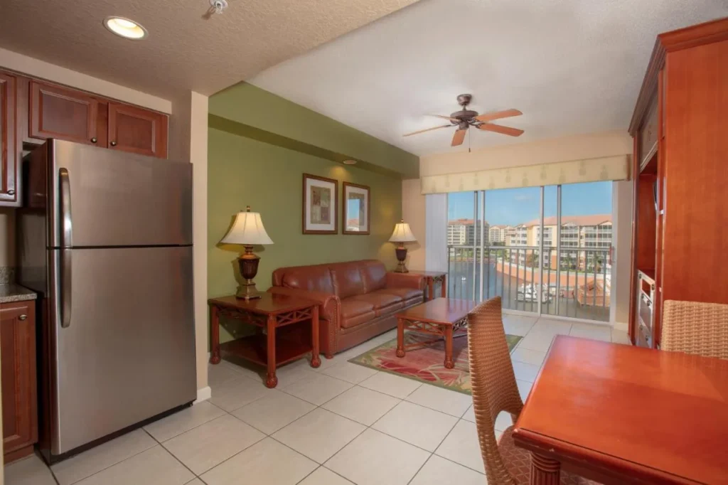 Villa living room with leather sofa, stainless fridge and balcony door at Westgate Town Center Resort