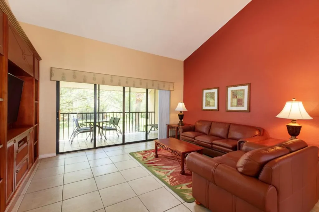 Villa de estar con sof&aacute;s de cuero y un balc&oacute;n en Westgate Vacation Villas Resort
