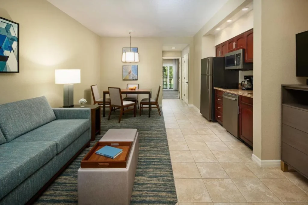 Villa living room with sofa, dining table and full kitchen at Sheraton Vistana Resort Villas