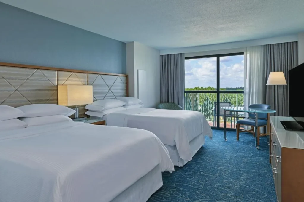 Walt Disney World Dolphin room with two beds and a furnished balcony over the trees