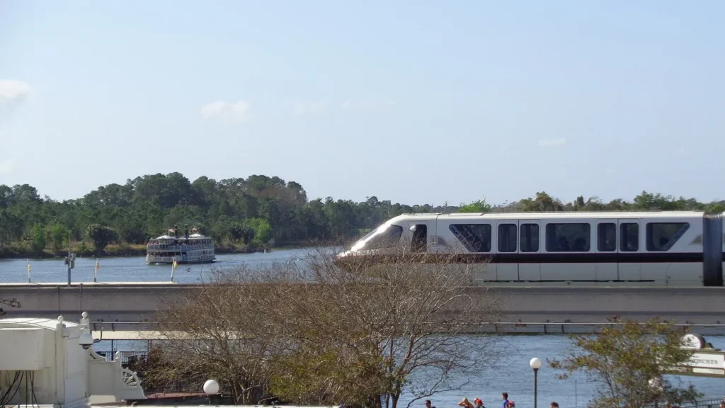 Walt Disney World monorail passing in front of a ferryboat crossing the Seven Seas Lagoon