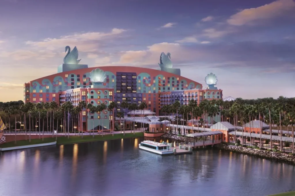 Walt Disney World Swan at dusk with swan statues and a FriendShip boat at the dock