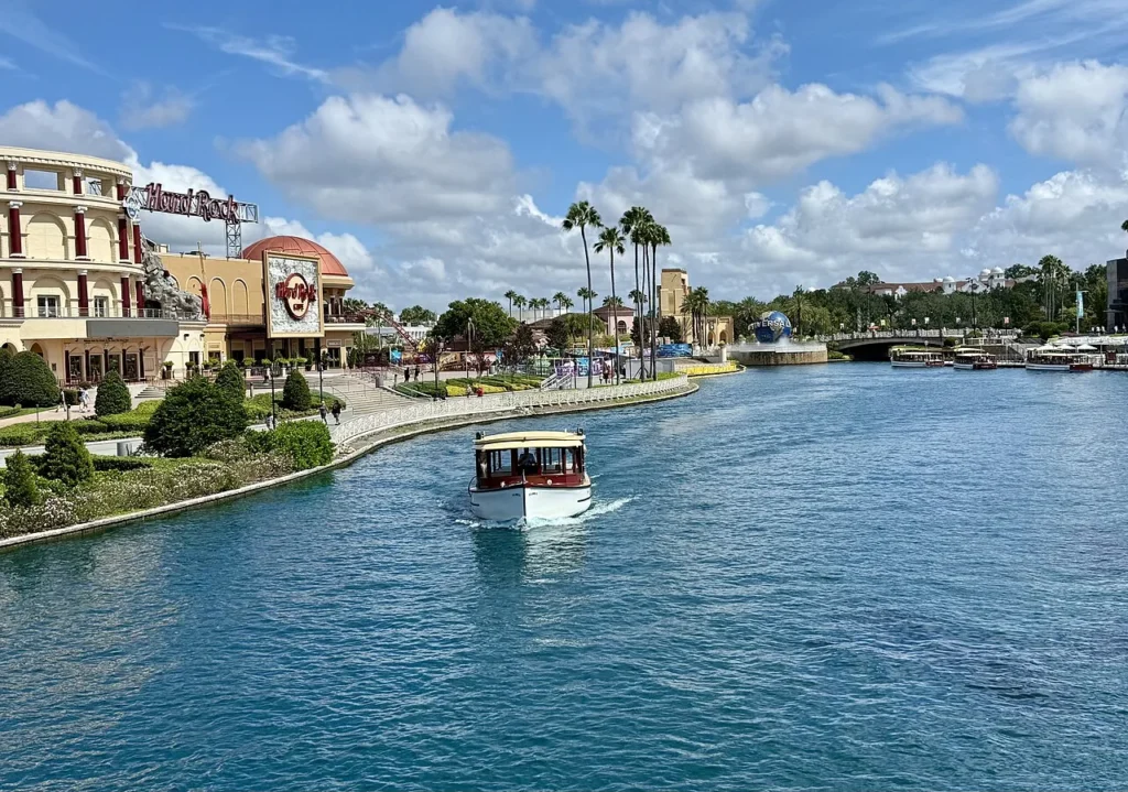 Water taxi crossing the Universal CityWalk waterway, with Hard Rock Cafe and the Universal globe behind