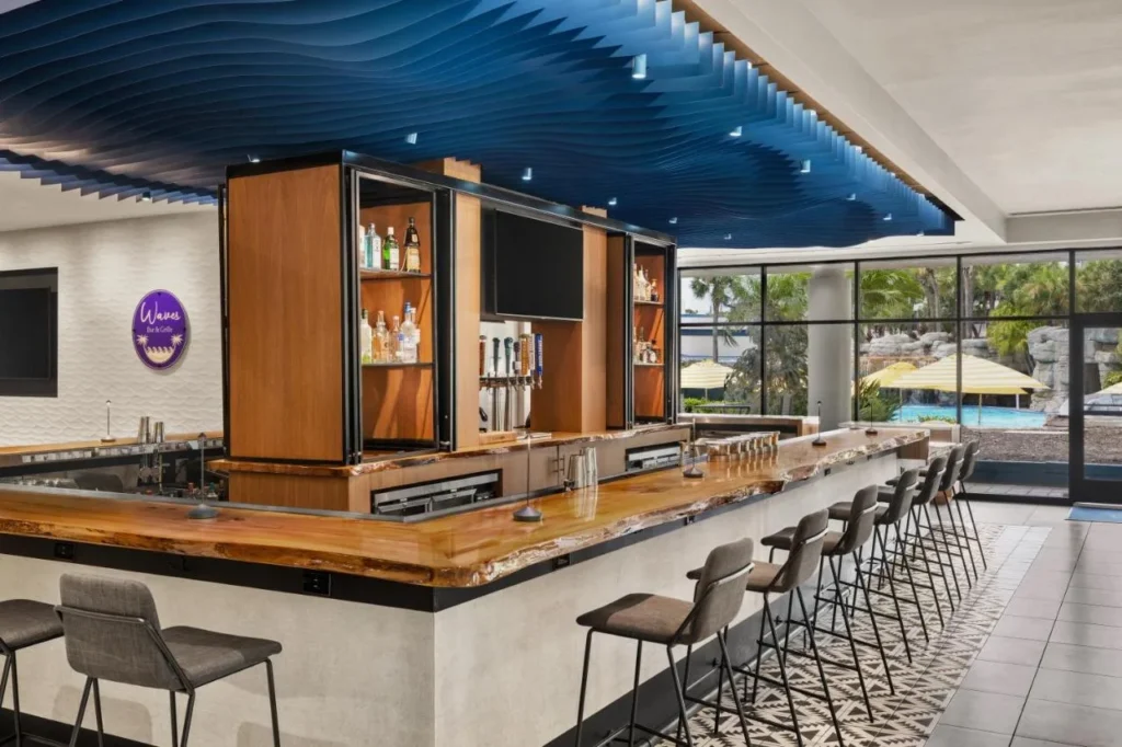 Contrafuerte de bar y parrilla bajo un techo de ola azul en Delta Hotels Orlando Celebration