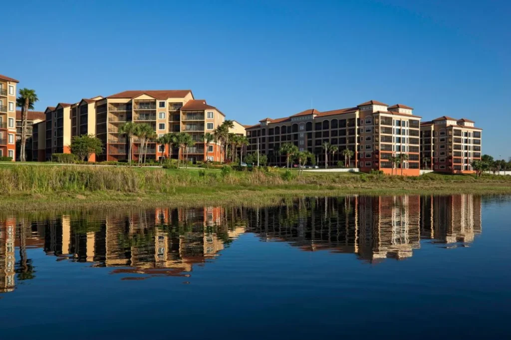 Westgate Lakes Resort and Spa villa buildings with balconies reflected in the lake