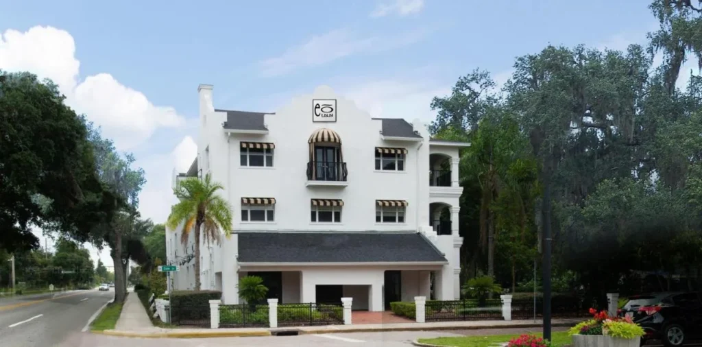 Edificio blanco de la d&eacute;cada de 1920 del EO Inn con toldos a rayas en North Eola Drive