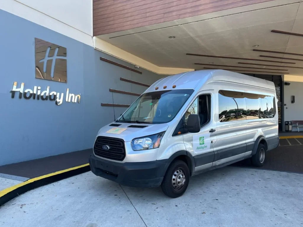 Furgoneta blanca estacionada junto al dosel de la entrada en el Holiday Inn Orlando International Airport