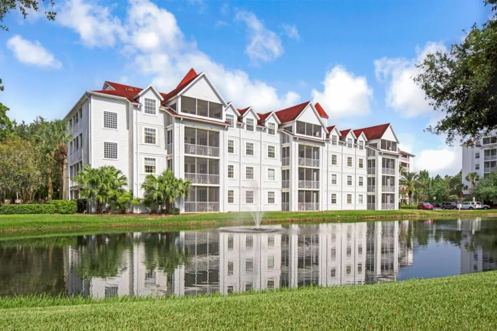 Edificios de suite blanca con techos rojos junto a un estanque en Hilton Vacation Club Grand Beach Orlando