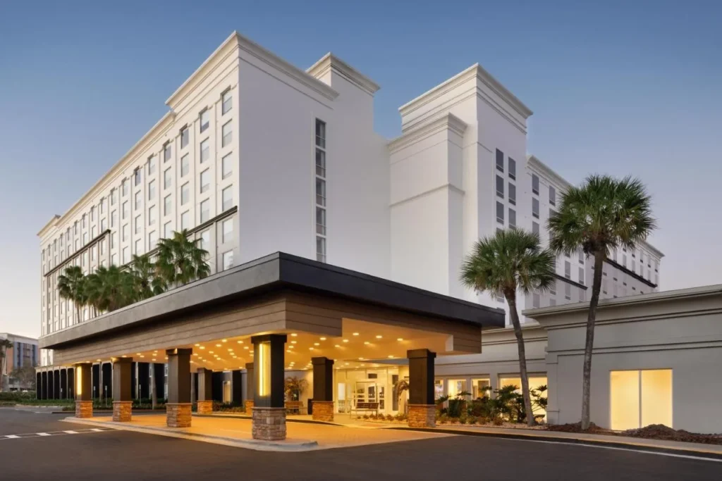 Torres blancas y porte-cochere iluminado al atardecer en el Courtyard by Marriott en Universal Orlando